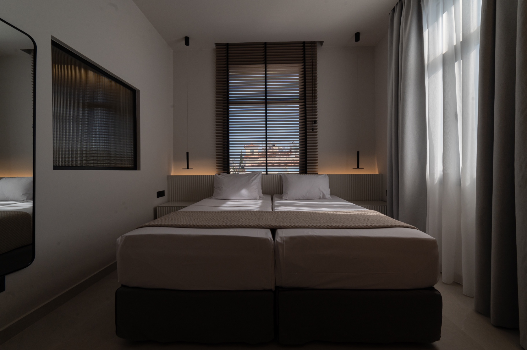 Deluxe Room with Extra Bed — twin bed configuration with wooden blinds