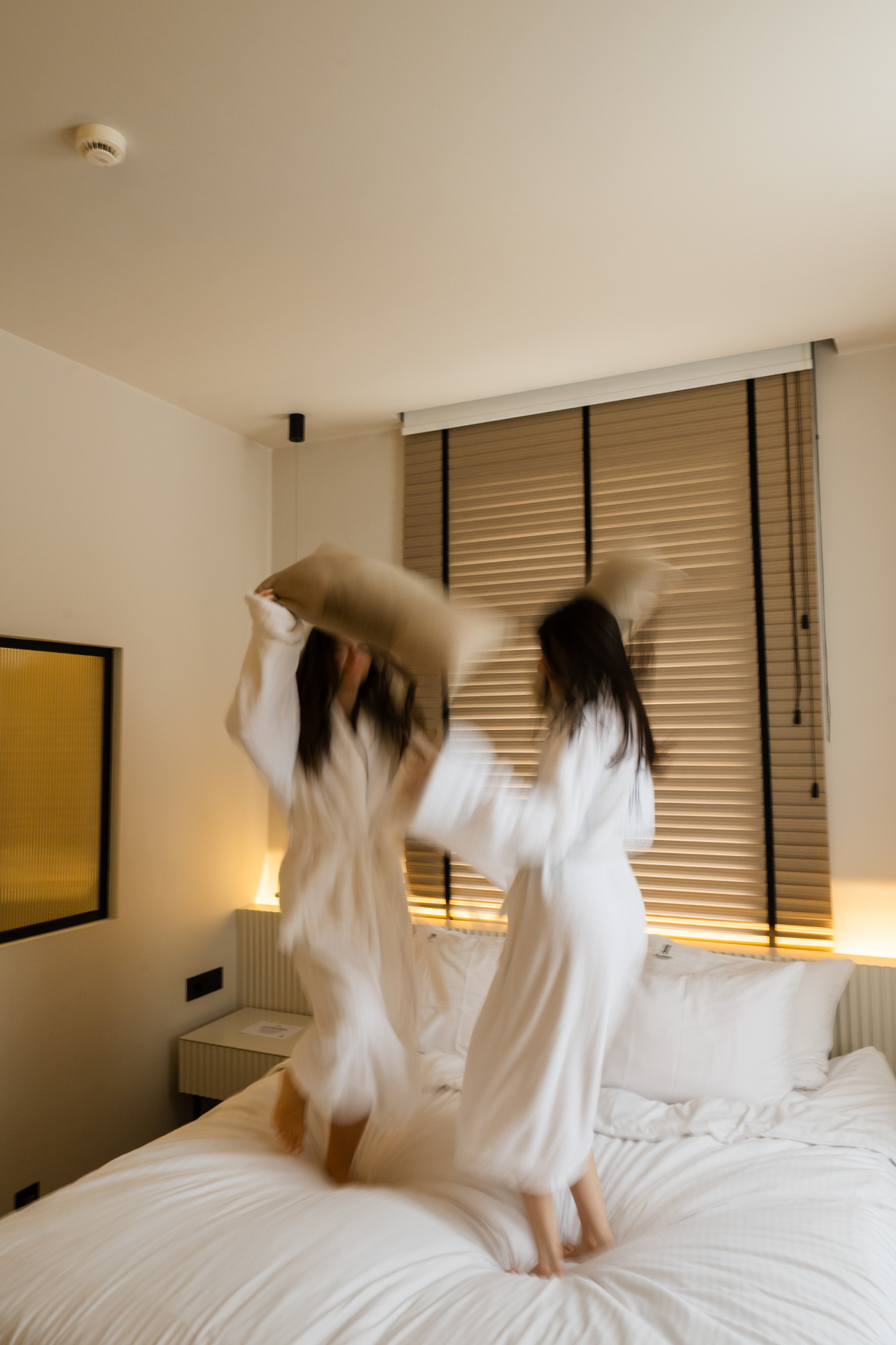 Deluxe Room with Extra Bed — playful moment in plush bathrobes