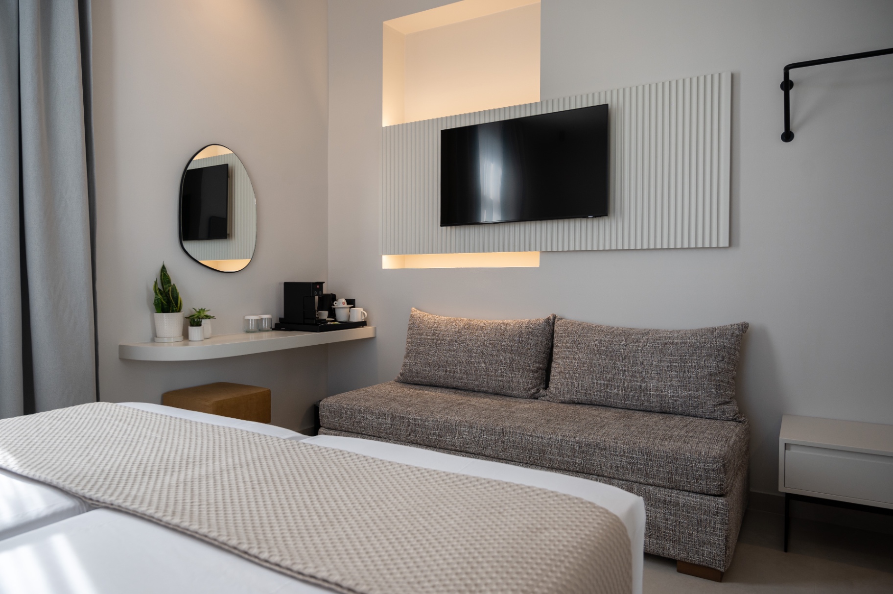 Deluxe Room with Extra Bed — sofa bed lounge detail with in-room amenities