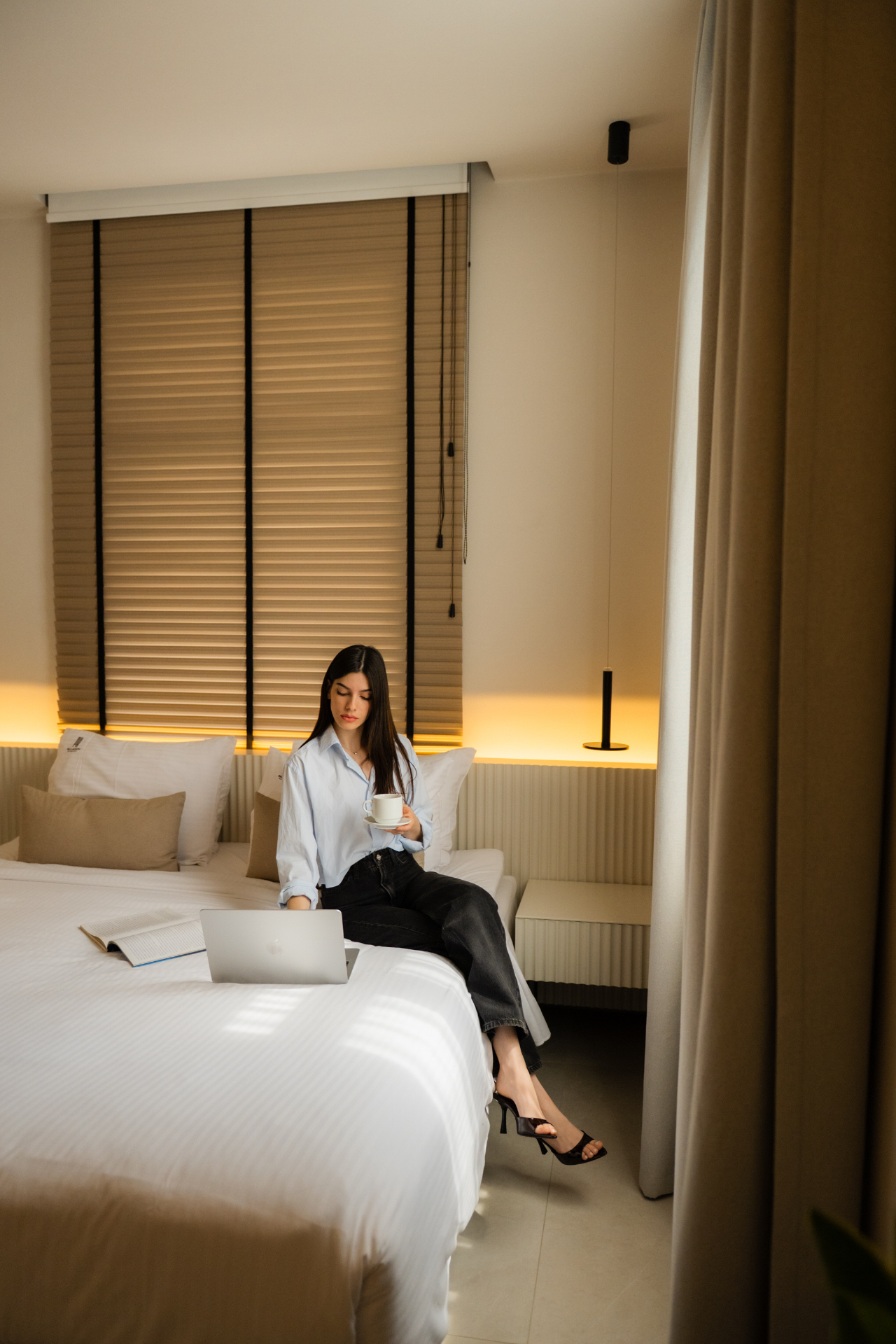 Deluxe Room with Extra Bed — working from bed with warm ambient lighting