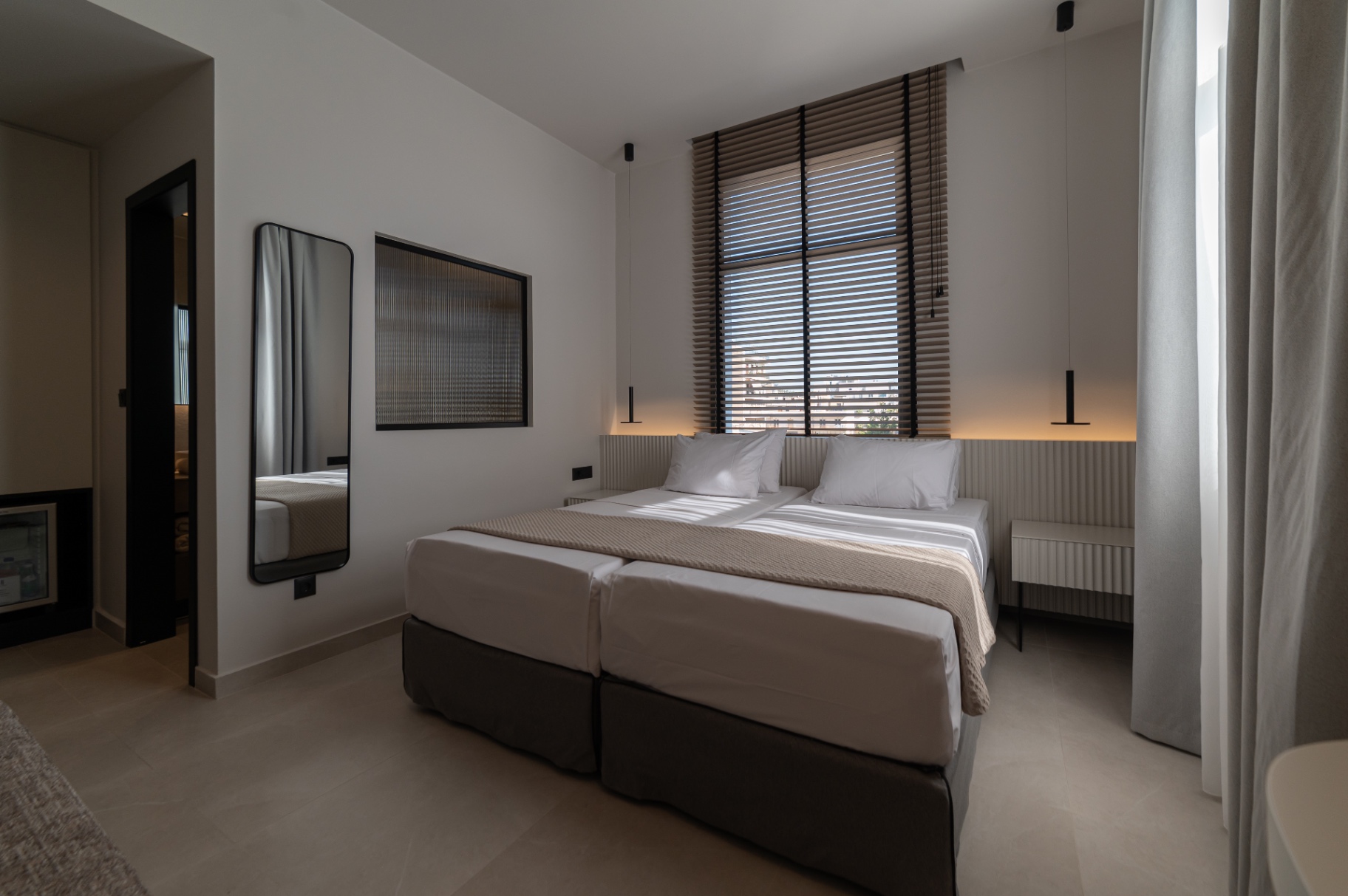 Deluxe Room with Extra Bed — bedroom side view with mirror and art
