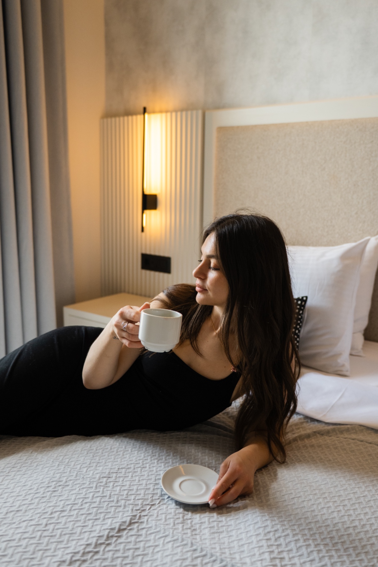 Superior room - espresso in bed with warm sconce lighting